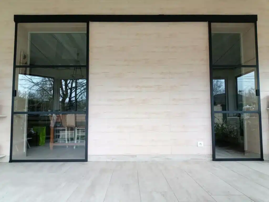 Verrière sur mesure coulissante noire sur façade en bois clair, au Mans.